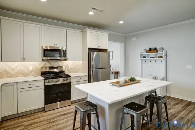 a kitchen with granite countertop a stove a refrigerator and a dining table