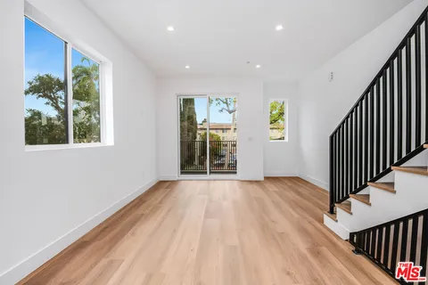 a view of a hallway with wooden floor and staircase