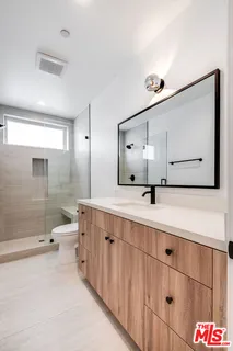 a bathroom with a double vanity sink mirror and shower