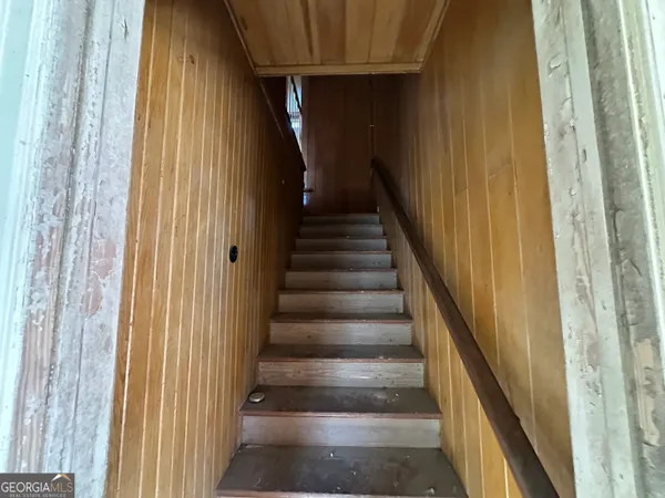 a view of a staircase with wooden floor and door