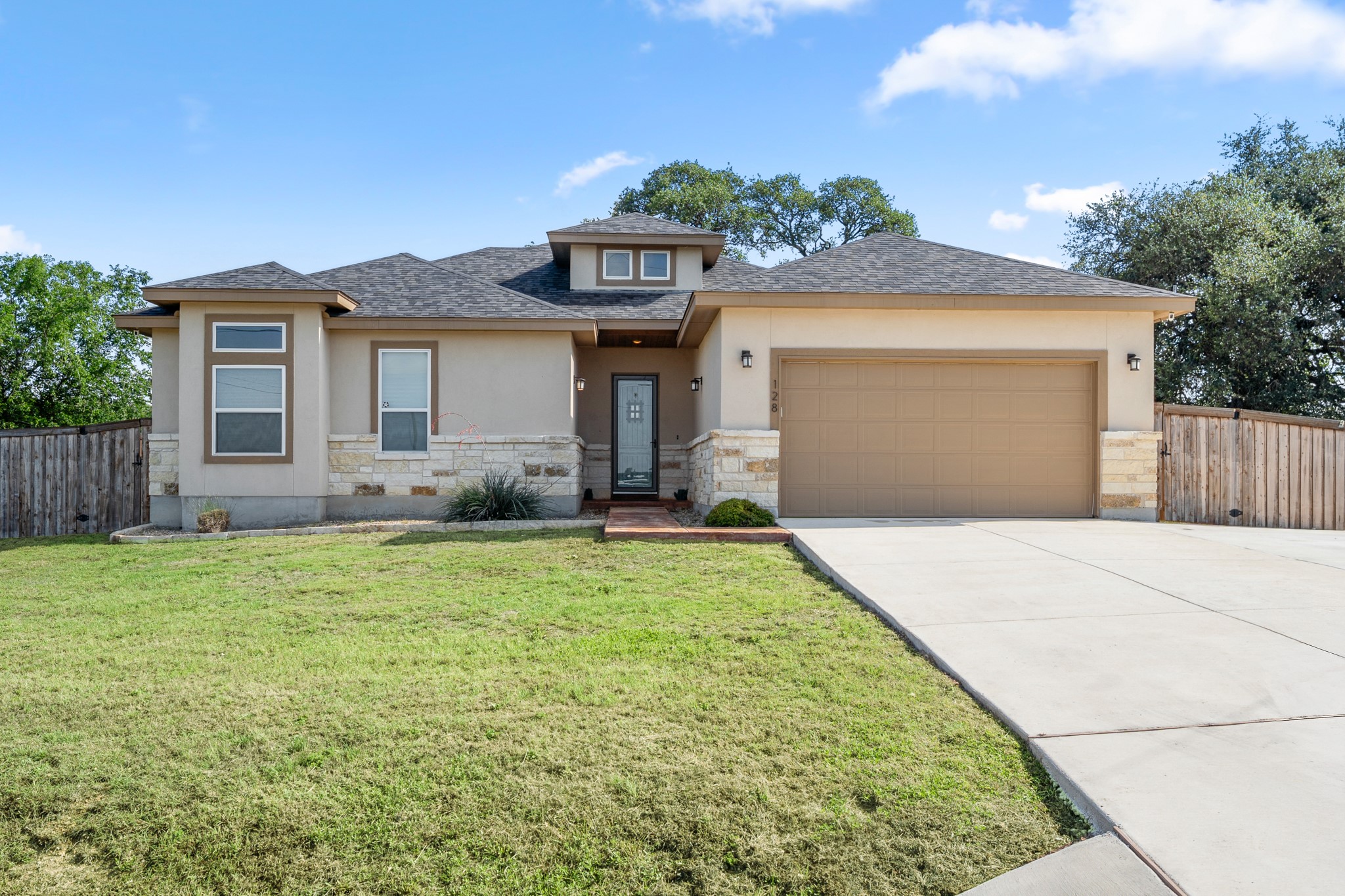 128 Hiram Cook Blanco, TX 78606 - Photo 3 of 40 Contemporary stucco exterior with stone accents and a dark shingle roof