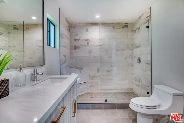 a bathroom with a tub sink toilet and a mirror
