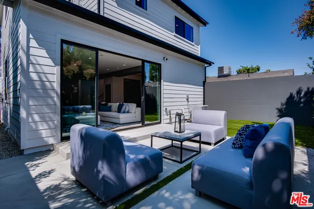 a view of a patio with couches table and chairs with garden view
