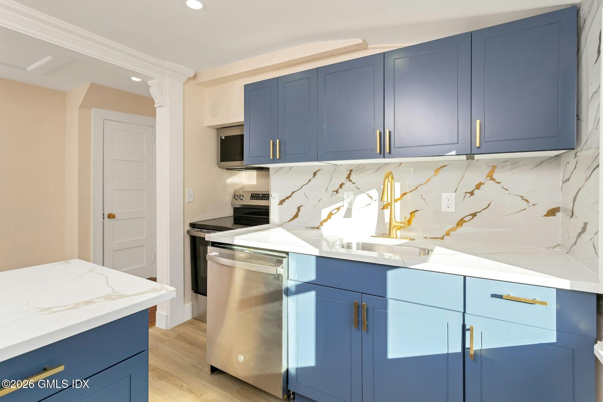 71 Prospect Street, Unit 2 Greenwich, CT 06830 - Photo 4 of 17 a kitchen with a sink a stove and cabinets
