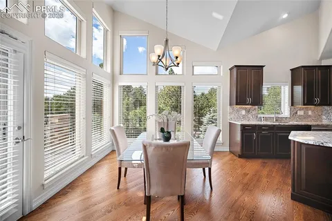 a view of a dining room with furniture a chandelier and wooden floor