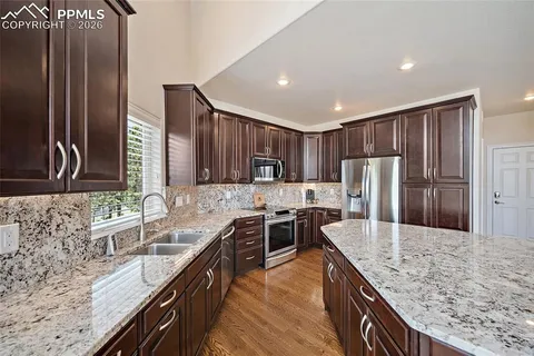 a kitchen with stainless steel appliances granite countertop a sink stove and refrigerator