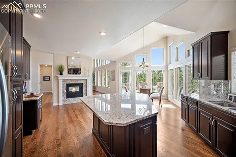 a open kitchen with granite countertop a stove oven and a refrigerator