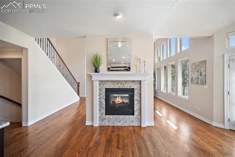 a living room with wooden floor and a fireplace