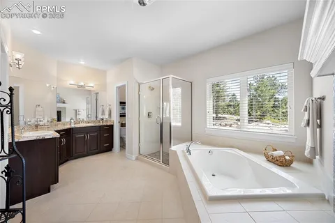 a large bathroom with a tub a double vanity sink a mirror and a shower