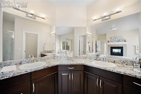 a bathroom with a granite countertop sink double vanity and a mirror