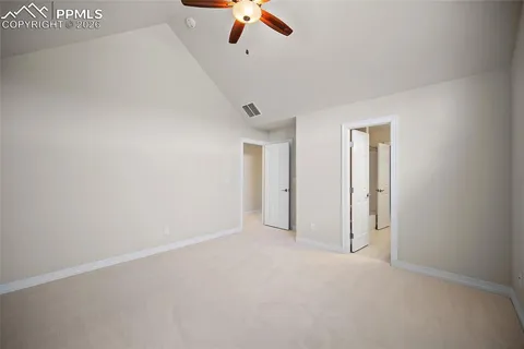 an empty room with ceiling fan and window