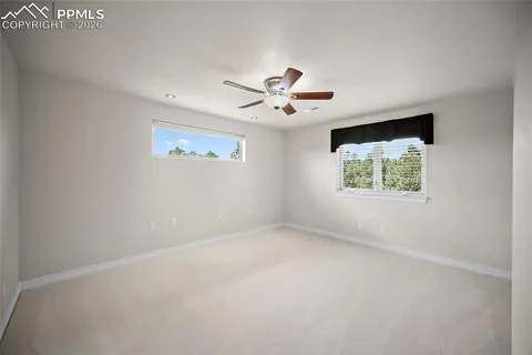 an empty room with a window and a fan