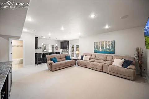 a living room with furniture and white kitchen