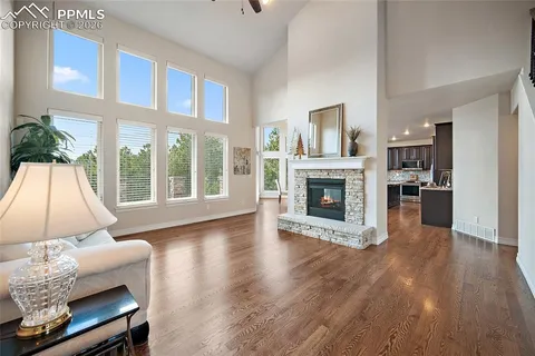 a view of a livingroom with furniture a fireplace and wooden floor
