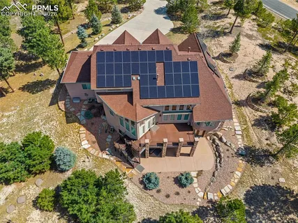 an aerial view of residential houses with outdoor space and trees