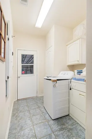 a brick house with trees in front of it