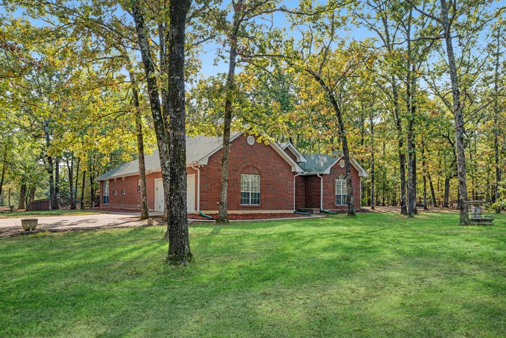 700 Hidden Lake Drive Powderly, TX 75473 - Photo 16 of 32 a front view of a house with a yard and trees