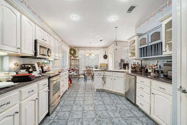a kitchen with stainless steel appliances a sink stove and cabinets