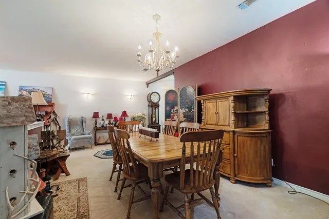 a view of a dining room with furniture and chandelier