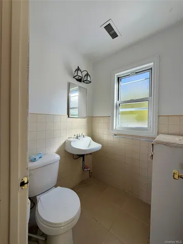 a bathroom with a toilet a sink and mirror