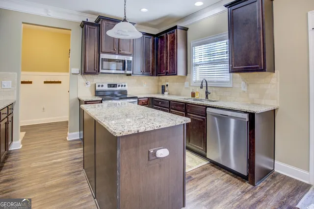 a kitchen with granite countertop a sink and a stove top oven