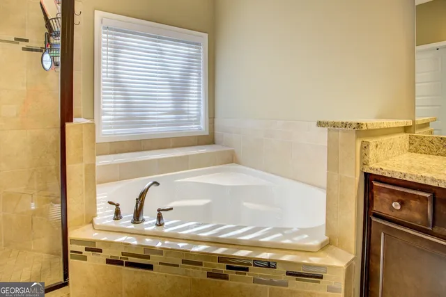 a bathroom with a granite countertop sink mirror and shower