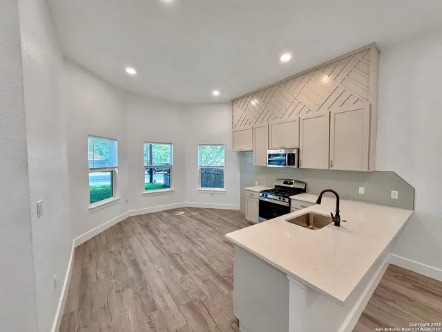 a kitchen with stainless steel appliances granite countertop a sink and cabinets