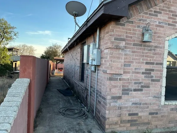 a pathway of a brick house with a yard