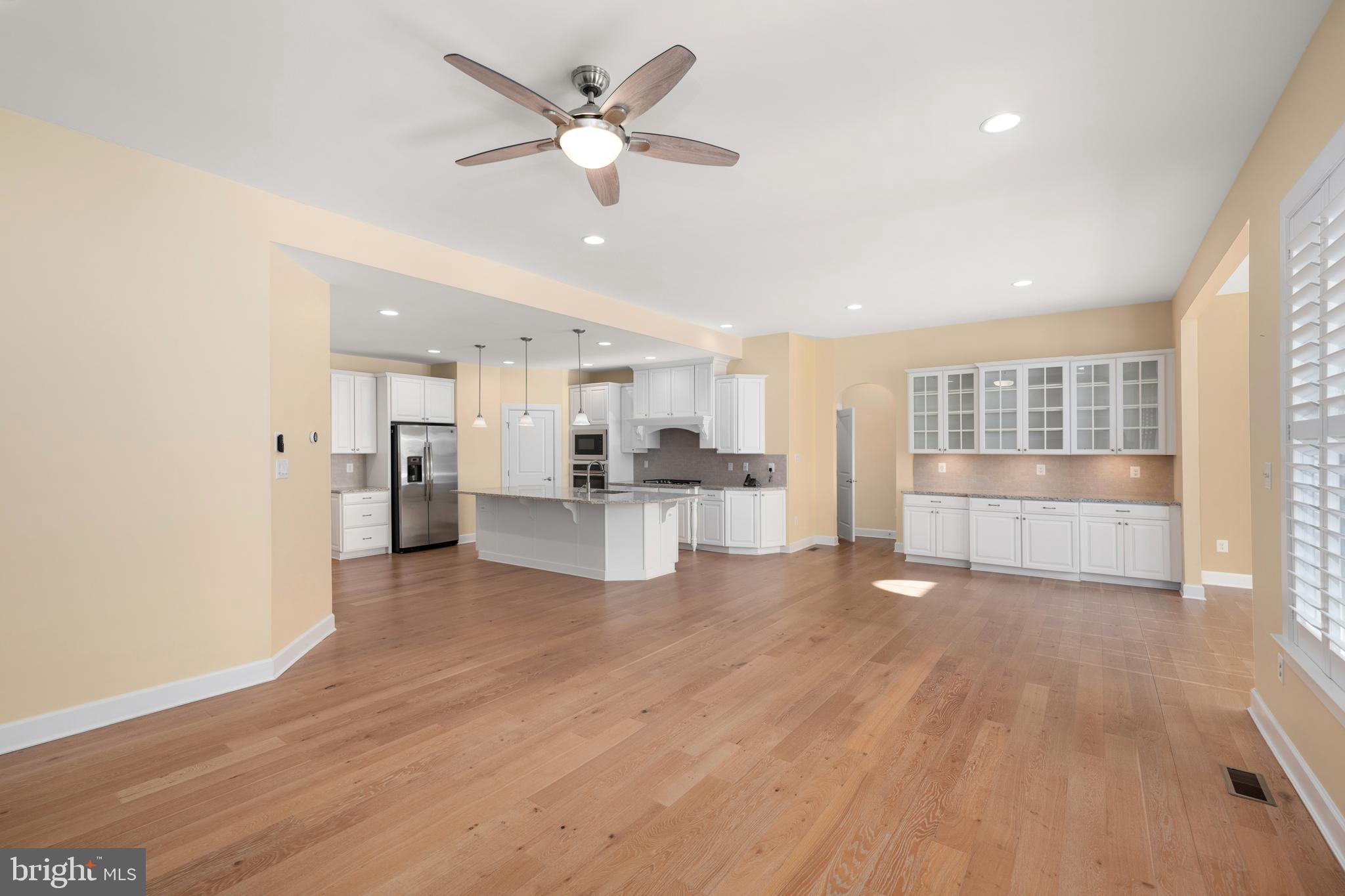 33415 Bridgehampton Lane Lewes, DE 19958 - Photo 12 of 66 a view of a big room with wooden floor and windows