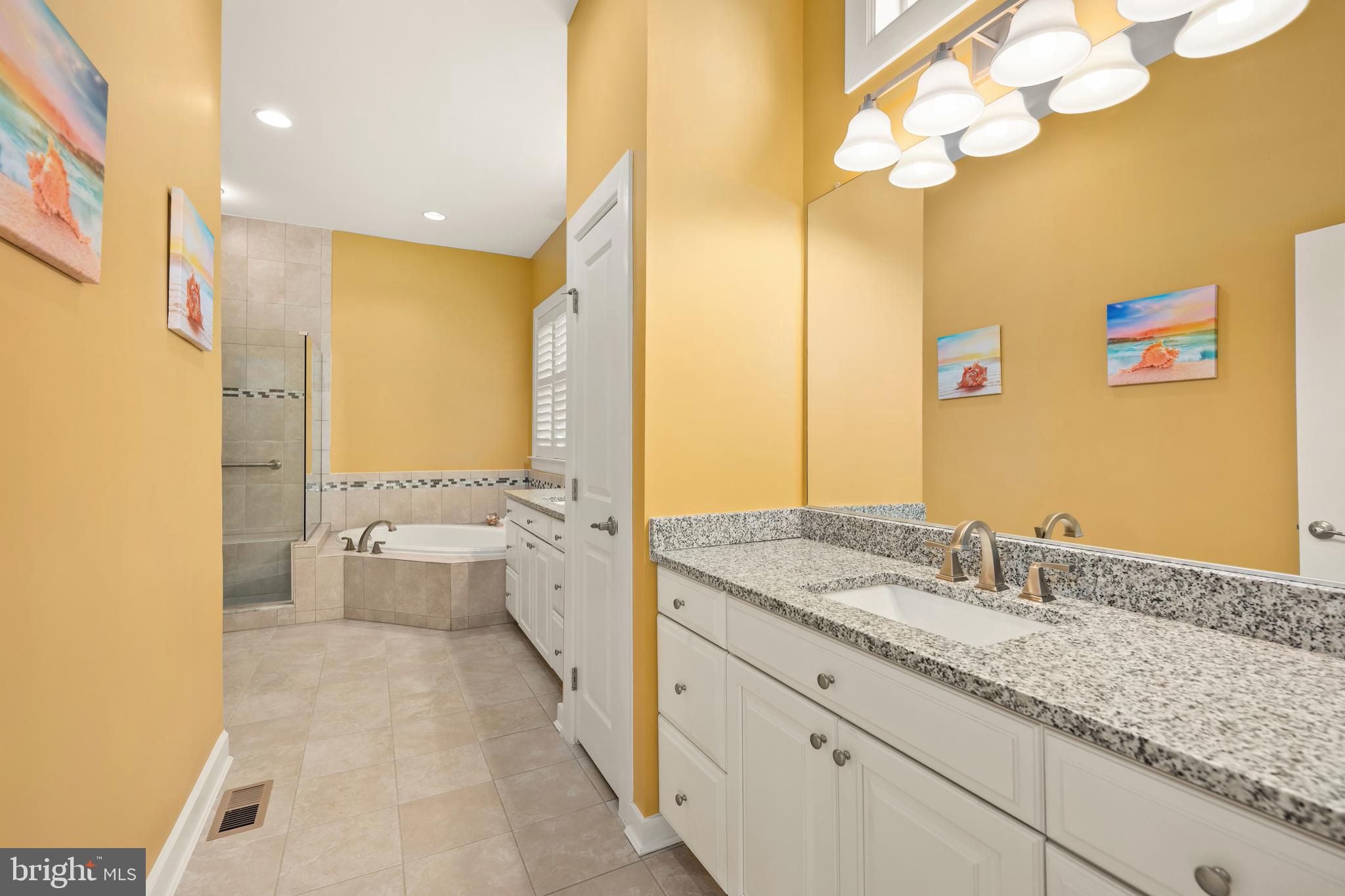 33415 Bridgehampton Lane Lewes, DE 19958 - Photo 18 of 66 a spacious bathroom with a granite countertop sink a toilet and a large mirror