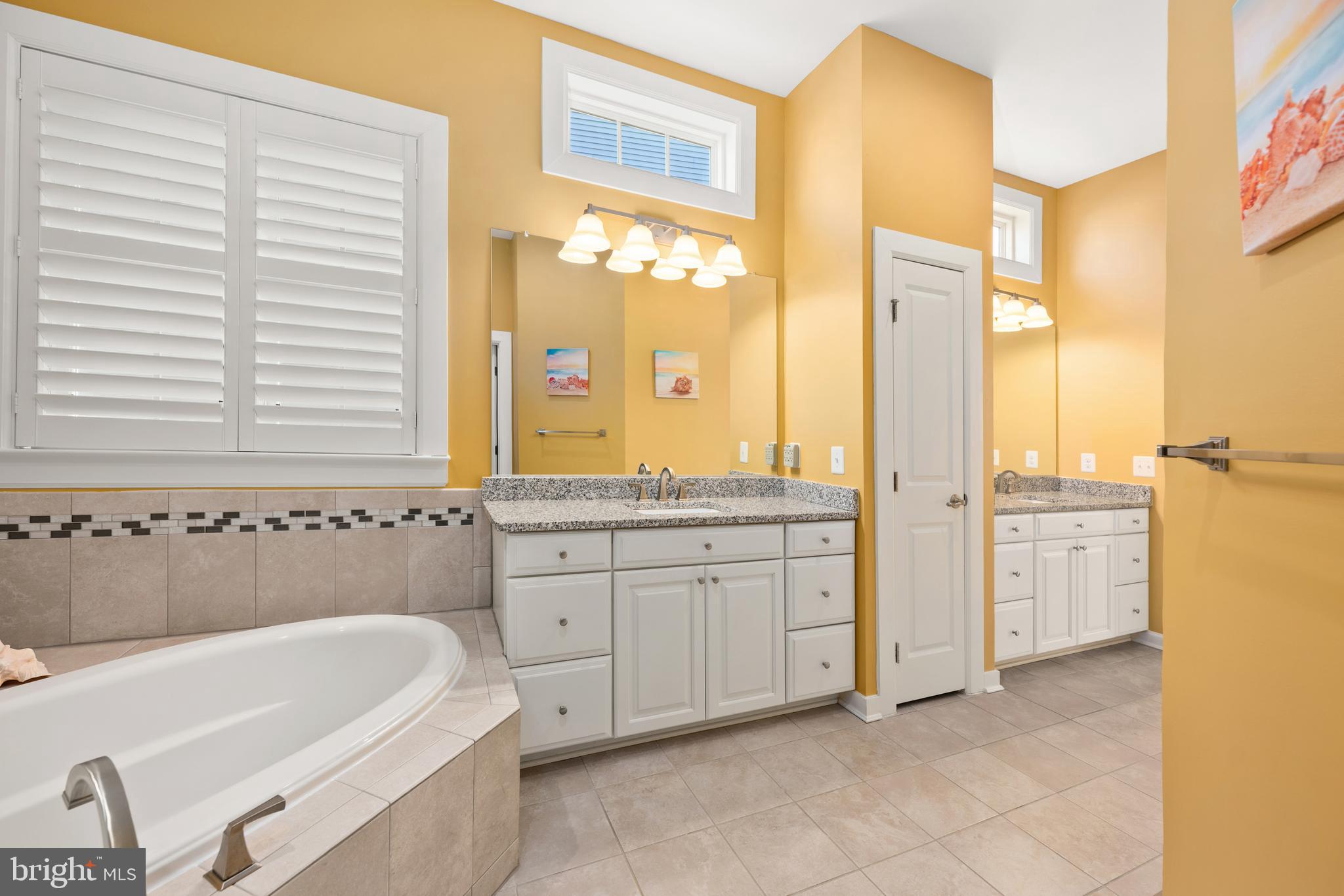 33415 Bridgehampton Lane Lewes, DE 19958 - Photo 20 of 66 a bathroom with a tub a sink and a large mirror