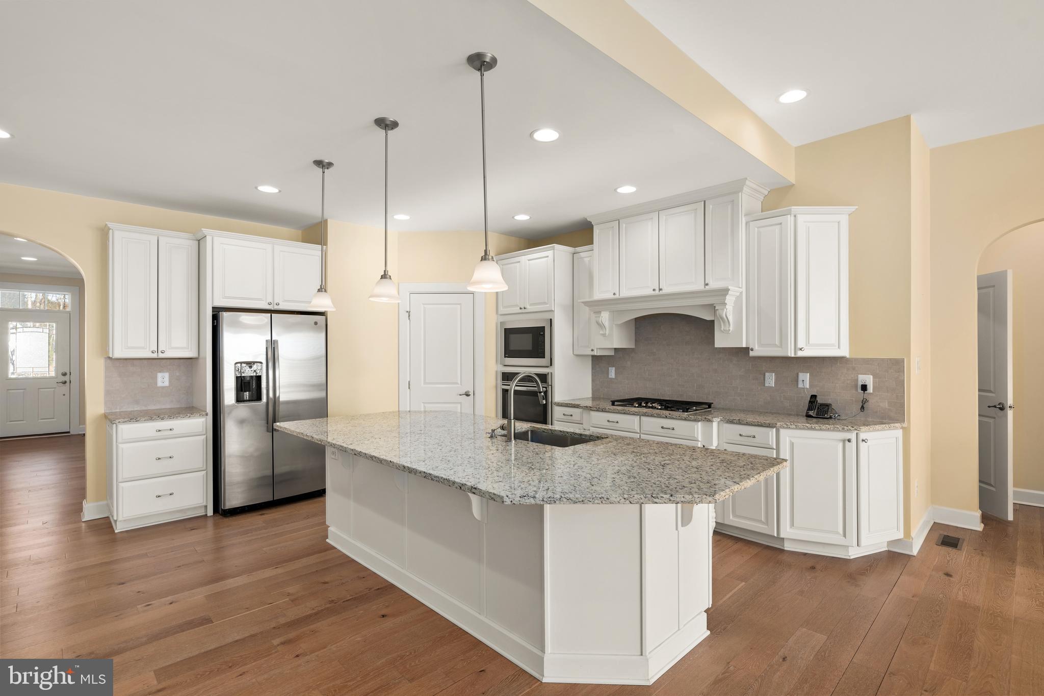 33415 Bridgehampton Lane Lewes, DE 19958 - Photo 5 of 66 a kitchen with stainless steel appliances granite countertop a refrigerator a sink a stove and a wooden floors