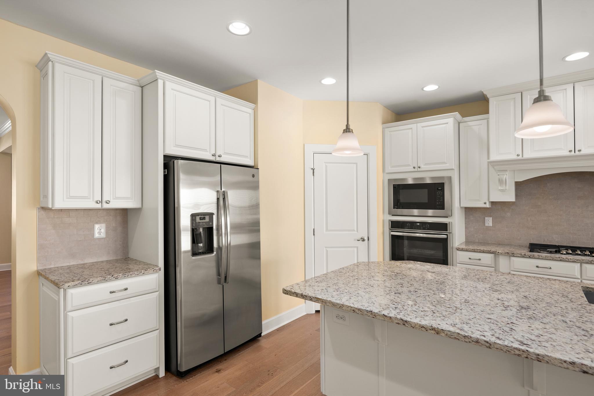 33415 Bridgehampton Lane Lewes, DE 19958 - Photo 7 of 66 a kitchen with stainless steel appliances granite countertop a refrigerator and a stove top oven