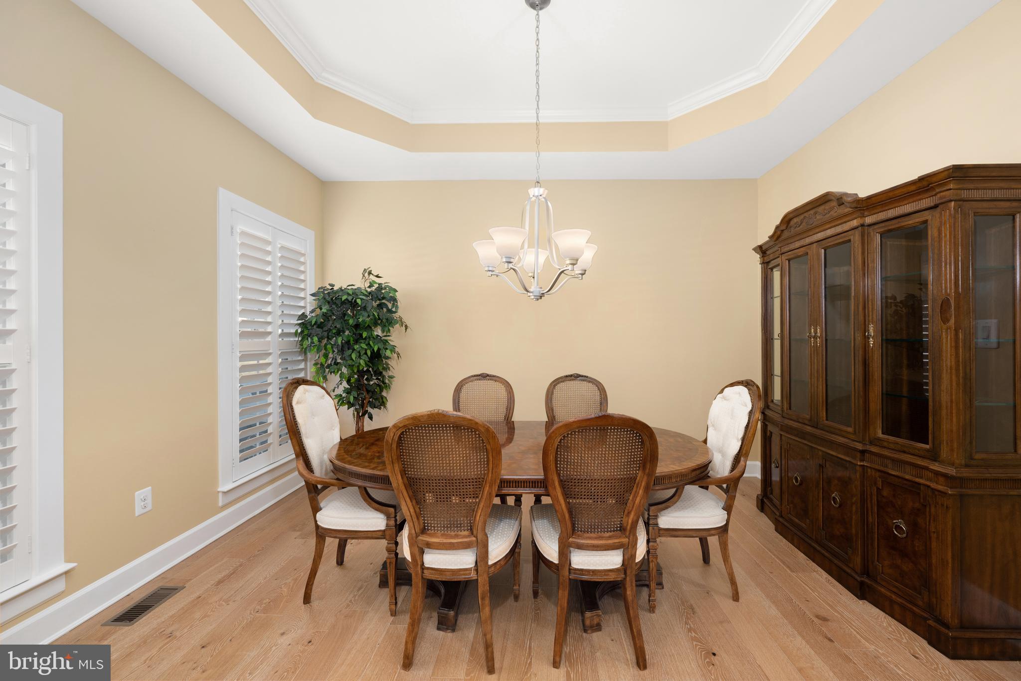 33415 Bridgehampton Lane Lewes, DE 19958 - Photo 9 of 66 a dining room with furniture a chandelier and wooden floor