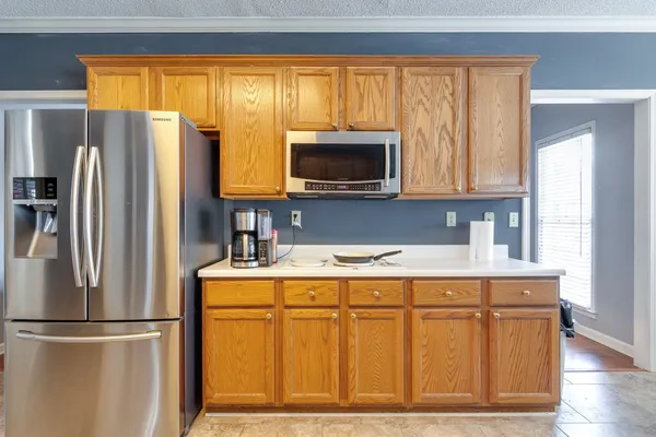 a kitchen with stainless steel appliances granite countertop a refrigerator a stove a microwave and wooden cabinets