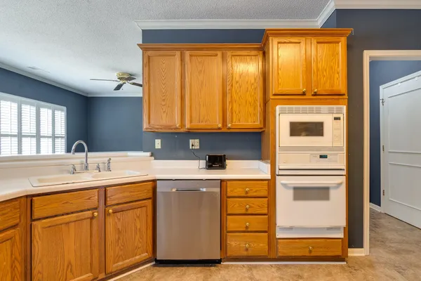 a kitchen with a sink cabinets appliances and a window