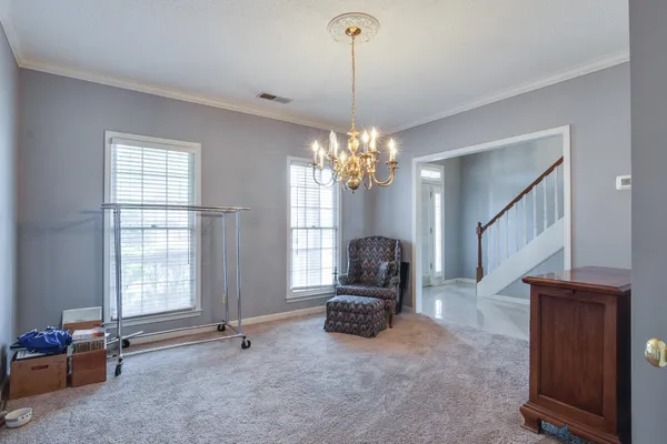a living room with furniture and a chandelier