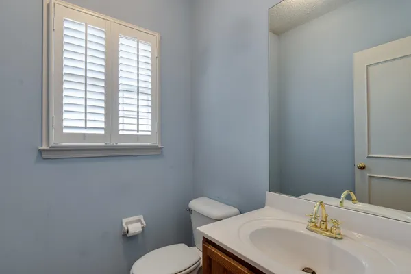 a bathroom with a sink a toilet and a window