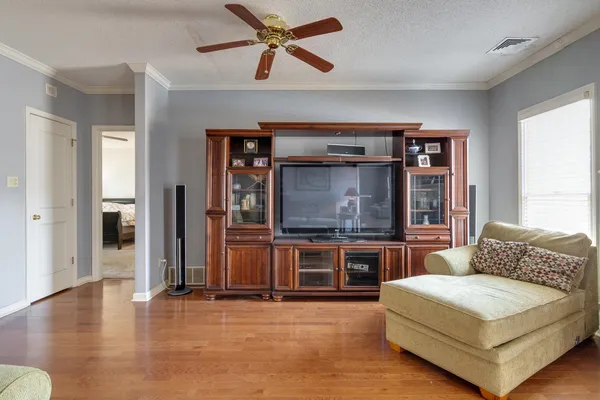 a living room with stainless steel appliances furniture and a kitchen view