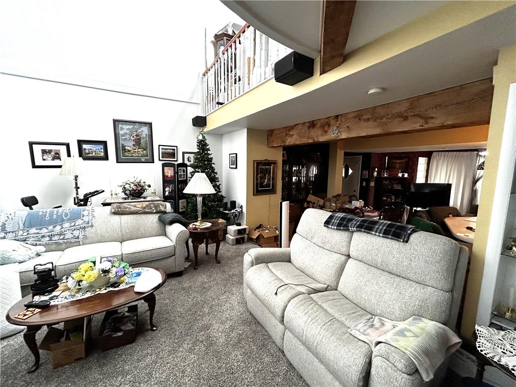 1214 Stanford Road Bethlehem, PA 18018 - Photo 26 of 58 A spacious living room features soaring ceilings, a second-story overlook, and exposed timber beams.