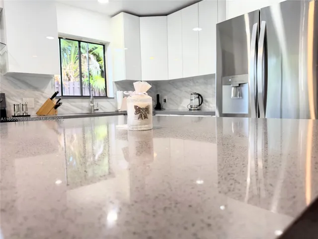 a kitchen with stainless steel appliances a sink a stove and a refrigerator with wooden floor