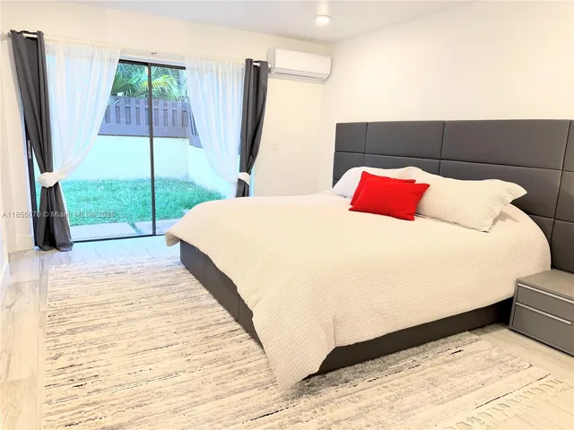 a bed sitting in a bedroom next to a window