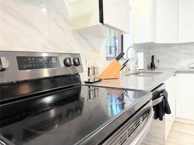 a view of kitchen with stove and refrigerator