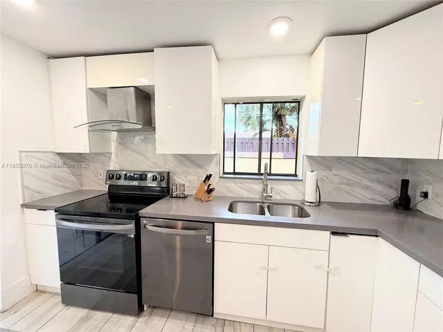 a kitchen with stainless steel appliances granite countertop a sink stove and cabinets
