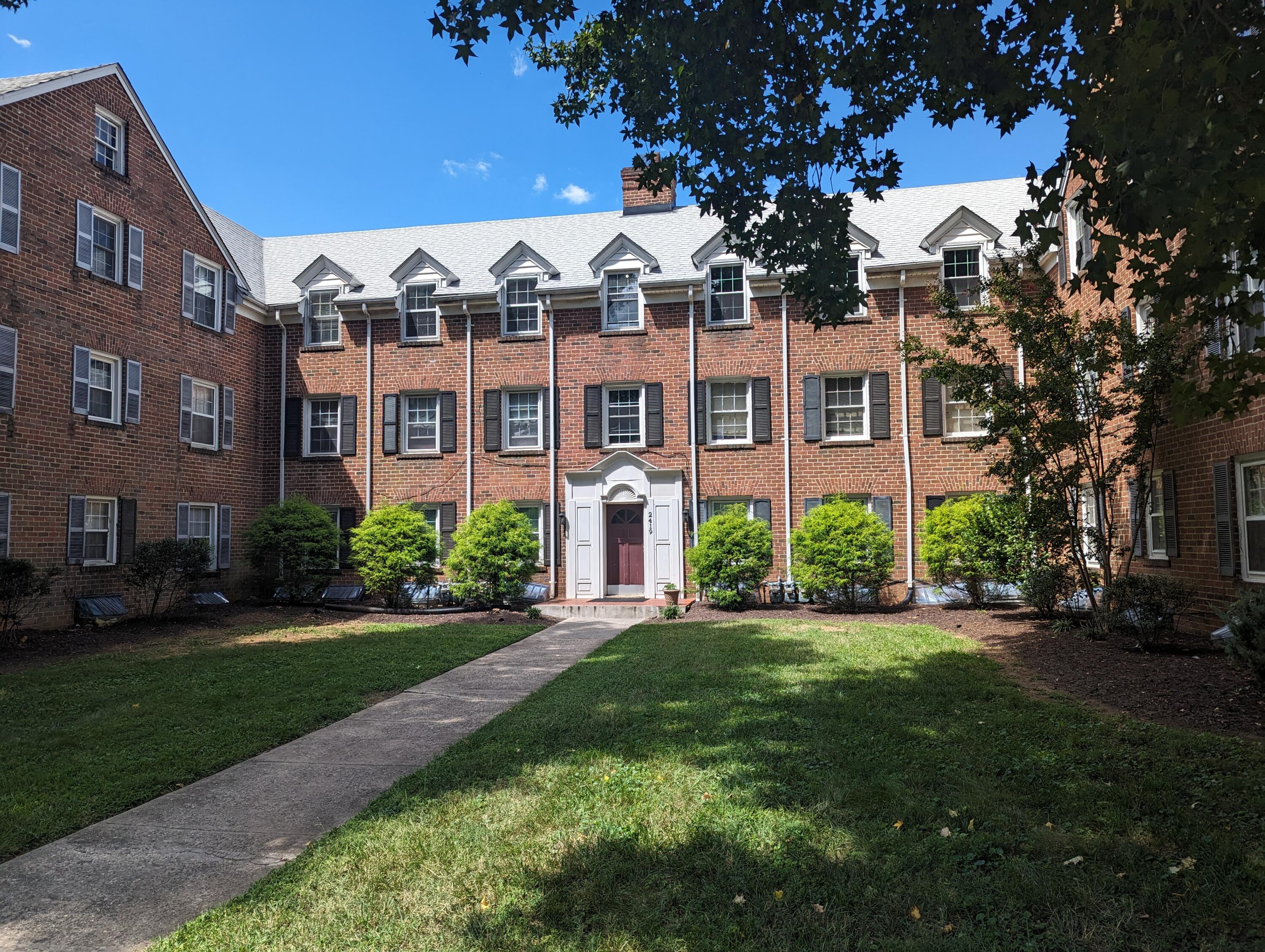 a front view of a residential apartment building with a yard
