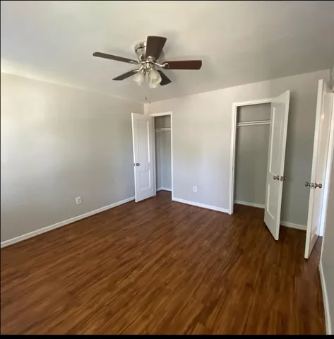 a view of a room with wooden floor and ceiling fan