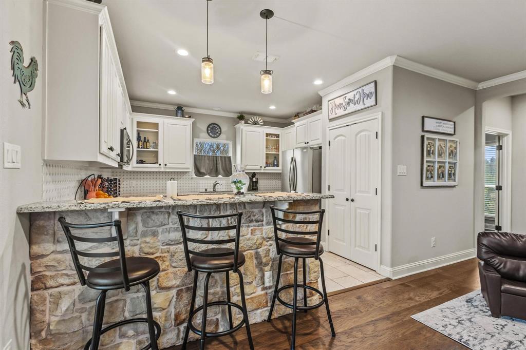 293 Redden Road Van Alstyne, TX 75495 - Photo 13 of 40 a kitchen with stainless steel appliances kitchen island granite countertop a dining table chairs and white cabinets