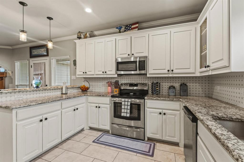 293 Redden Road Van Alstyne, TX 75495 - Photo 15 of 40 a kitchen with stainless steel appliances granite countertop a sink and cabinets