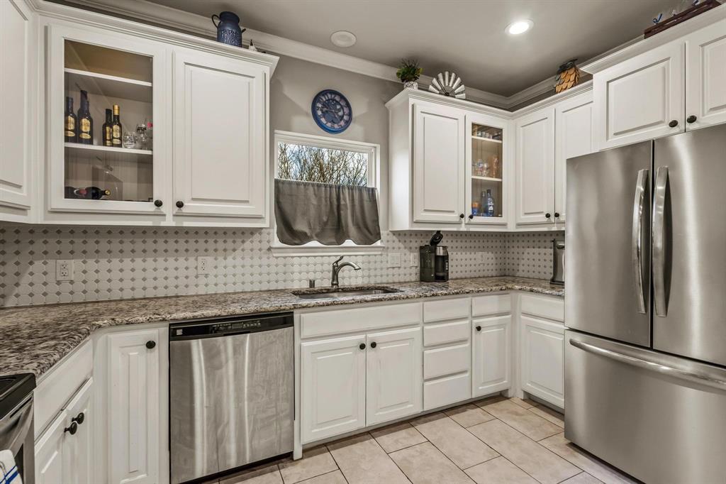 293 Redden Road Van Alstyne, TX 75495 - Photo 16 of 40 a kitchen with white cabinets and stainless steel appliances
