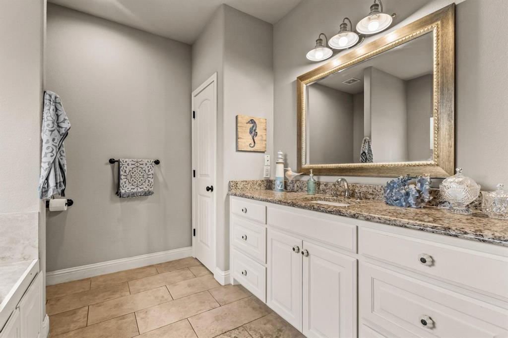 293 Redden Road Van Alstyne, TX 75495 - Photo 27 of 40 a bathroom with a granite countertop sink and a mirror